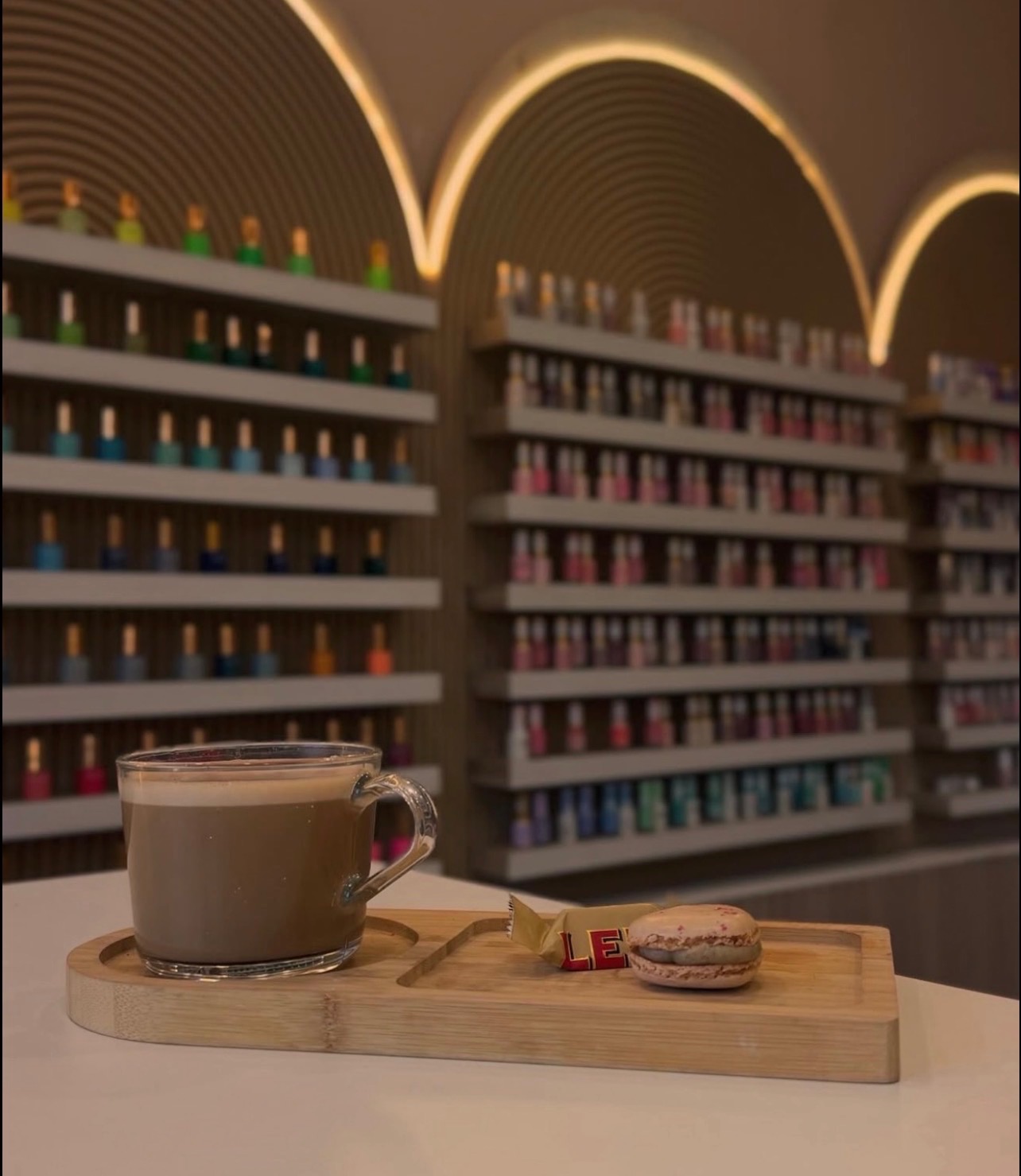 Complimentary latte and macaron served on a wooden tray